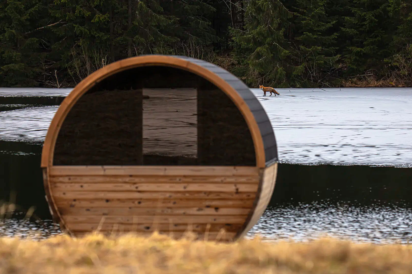 Hekla Barrel Sauna 250 rear view by a lake (lifestyle image).