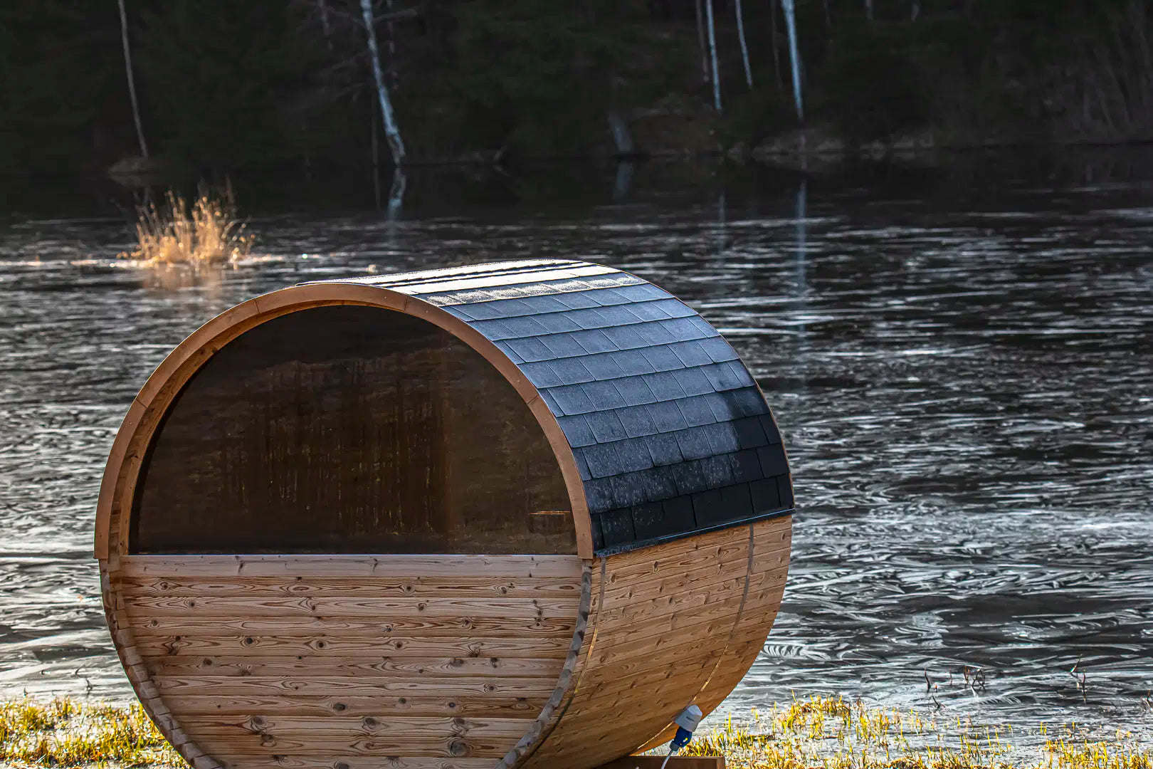 Hekla Barrel Sauna 250 rear view by a lake with multiple units (lifestyle image).