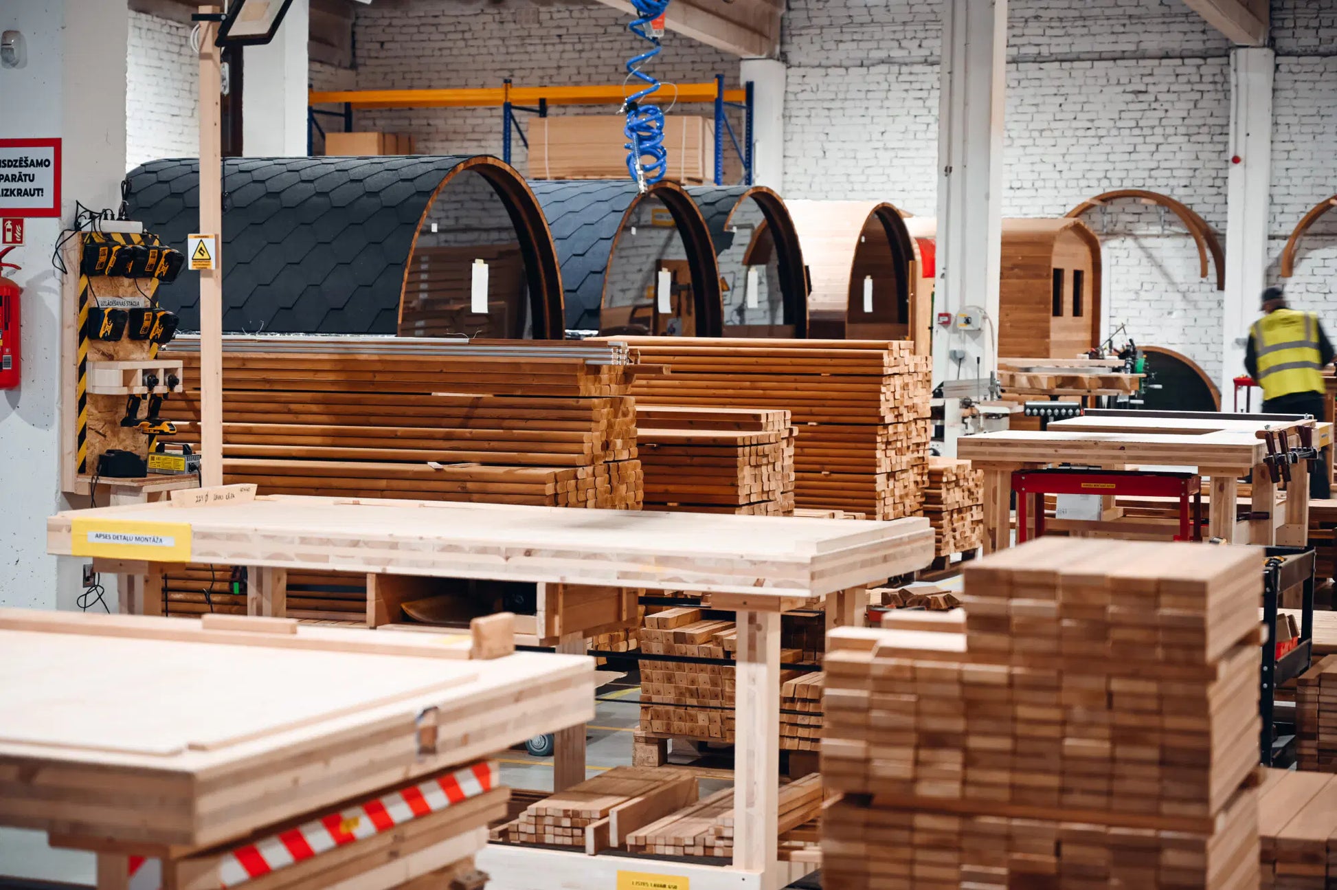 Factory workshop image showing multiple barrel sauna units.