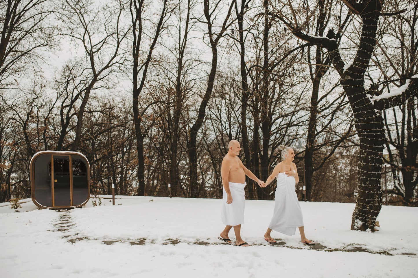 Hekla Cube Sauna 210 outdoor cube sauna, lifestyle snow couple walking.